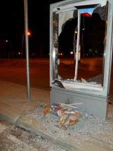 A smashed glass billboard holder lays testament to the frenzied riot outside the airport.